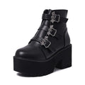 Black women's punk ankle boots with bat buckle and side zip on a thick sole.