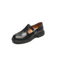 Women's black British style leather flat shoe with round toe and slip-on design on a neutral background.