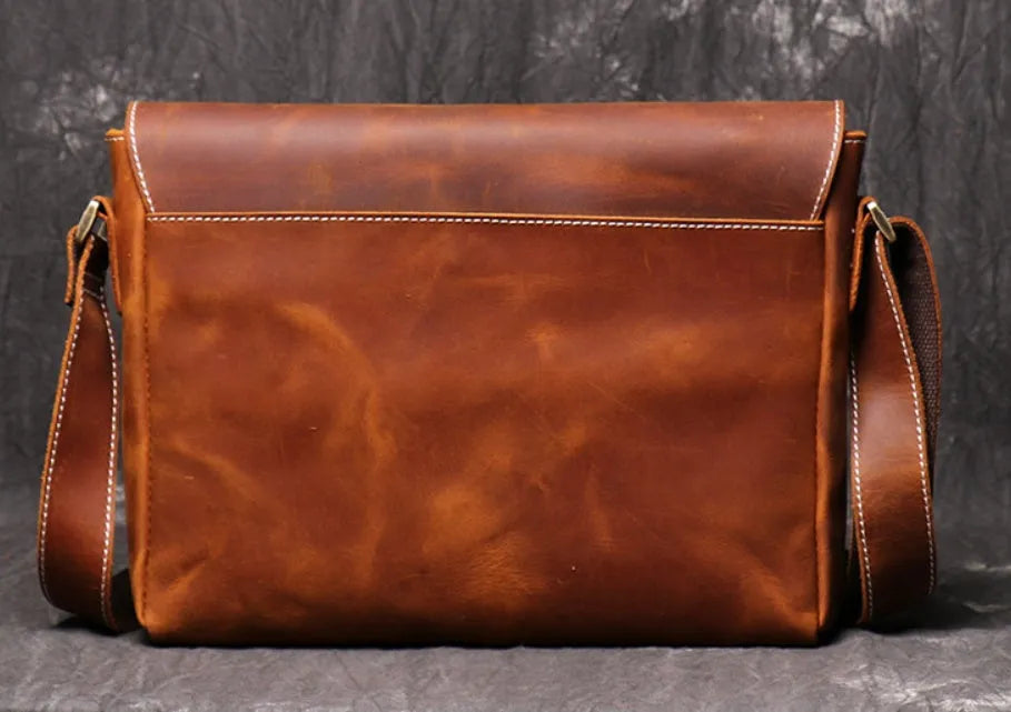 Vintage brown cowhide men's messenger bag showing front flap and adjustable shoulder strap