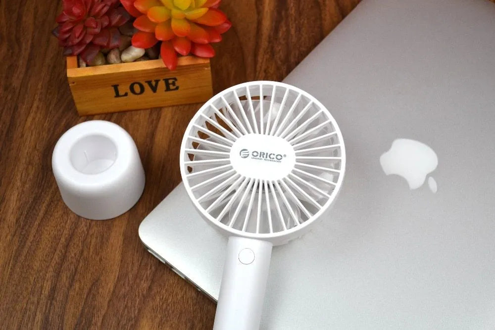 White ORICO FH1 portable USB rechargeable small fan on a desktop.