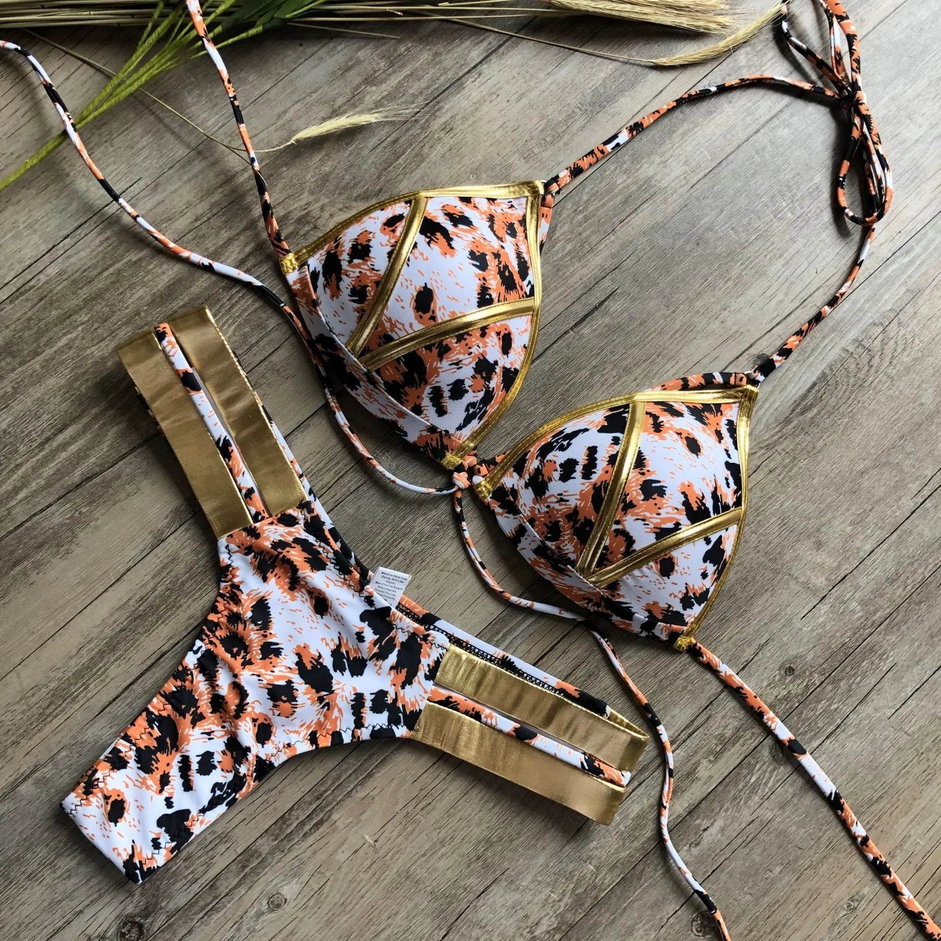 Women's bronzing bikini top and bottom set on a mannequin, showing adjustable straps.