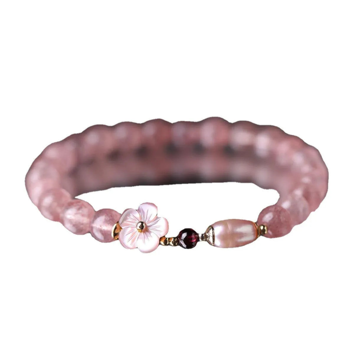 Women's strawberry quartz peach blossom crystal bracelet with floral design on wrist.