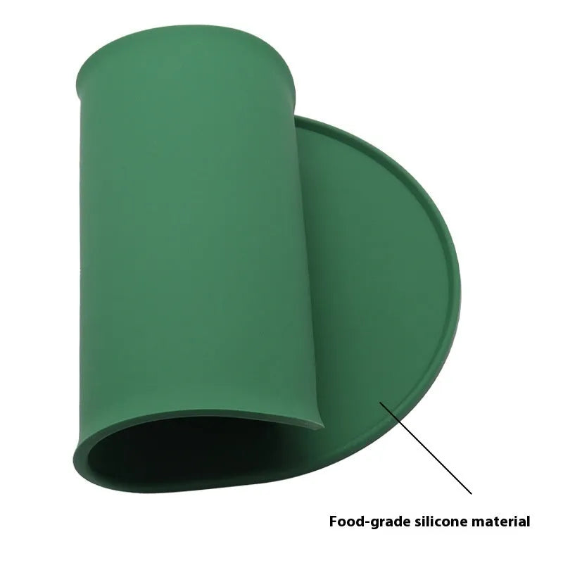 Green silicone waterproof placemat for cat food and water bowls on a floor.