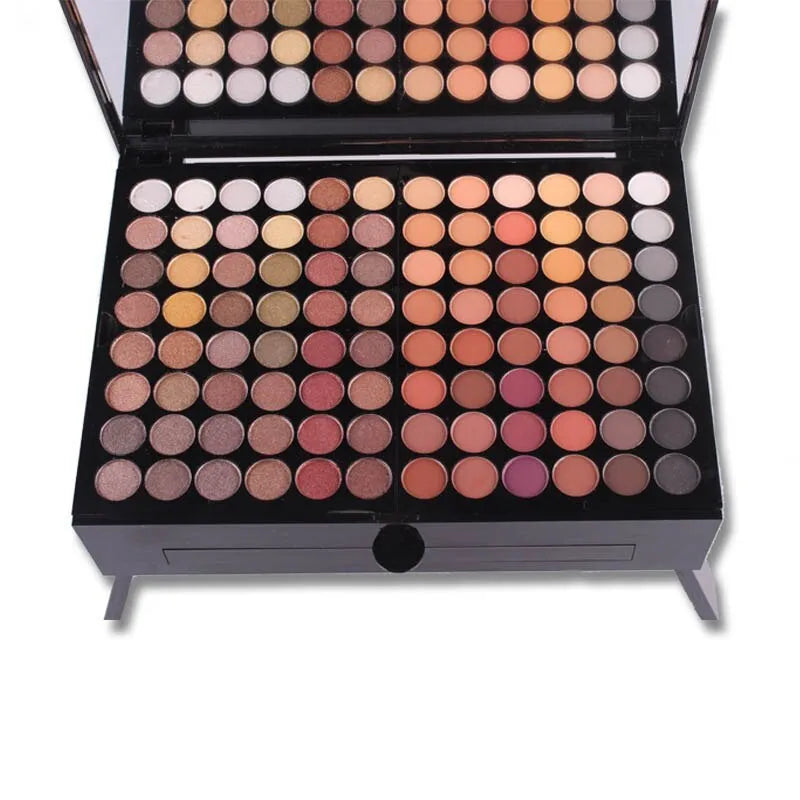 Piano-shaped open makeup palette displaying 180 eyeshadow colours, 2 blushes, 2 powders, and 6 powder outlines.
