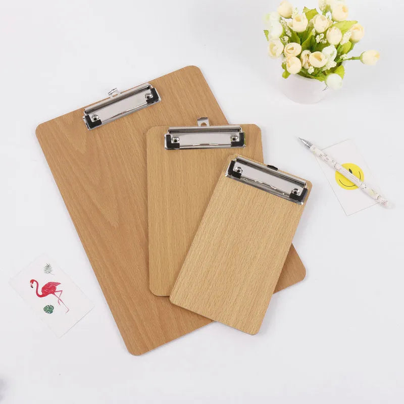 A4 wooden clipboard with metal clip and hanging hole placed on a desk