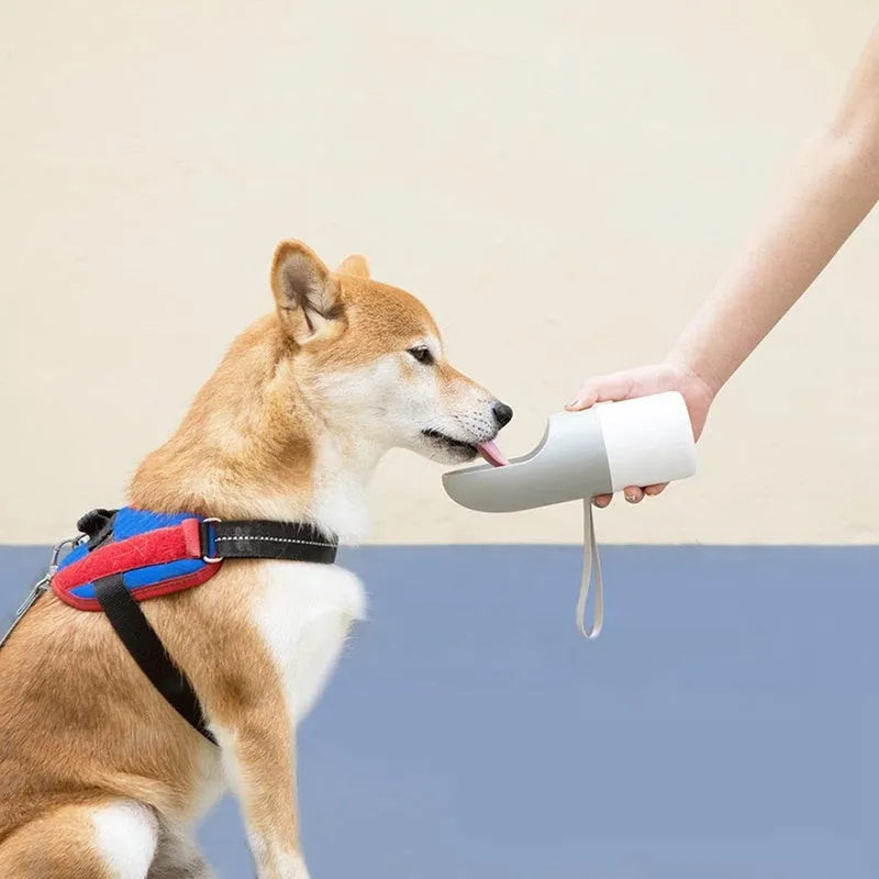 White MOESTAR rocket-shaped pet drinking cup with grey or orange accents showing one-button lock