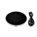 Black USB heating coaster pad for cups with LED indicator light on a wooden desk.