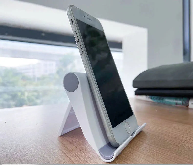 A black PE plastic folding stand holding a mobile phone at an angle.