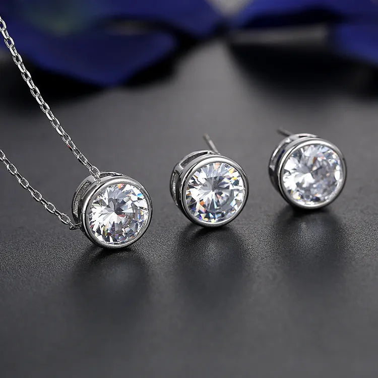 Bridal pendant and earring set with diamond-cut metal alloy finish on white background