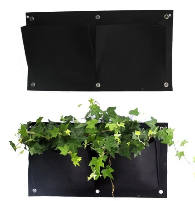 Green vertical felt wall planter with multiple planting pockets hanging on a fence, filled with herbs.
