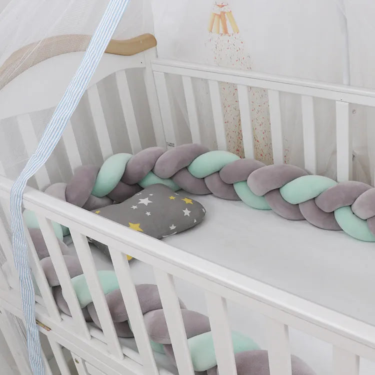 Bendable braid knot baby crib bumper in spandex velvet fabric on a white cot.