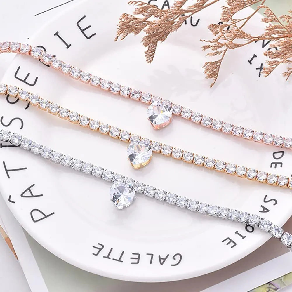 Gold heart-shaped rhinestone dog collar on a white background, showing shiny bling design.