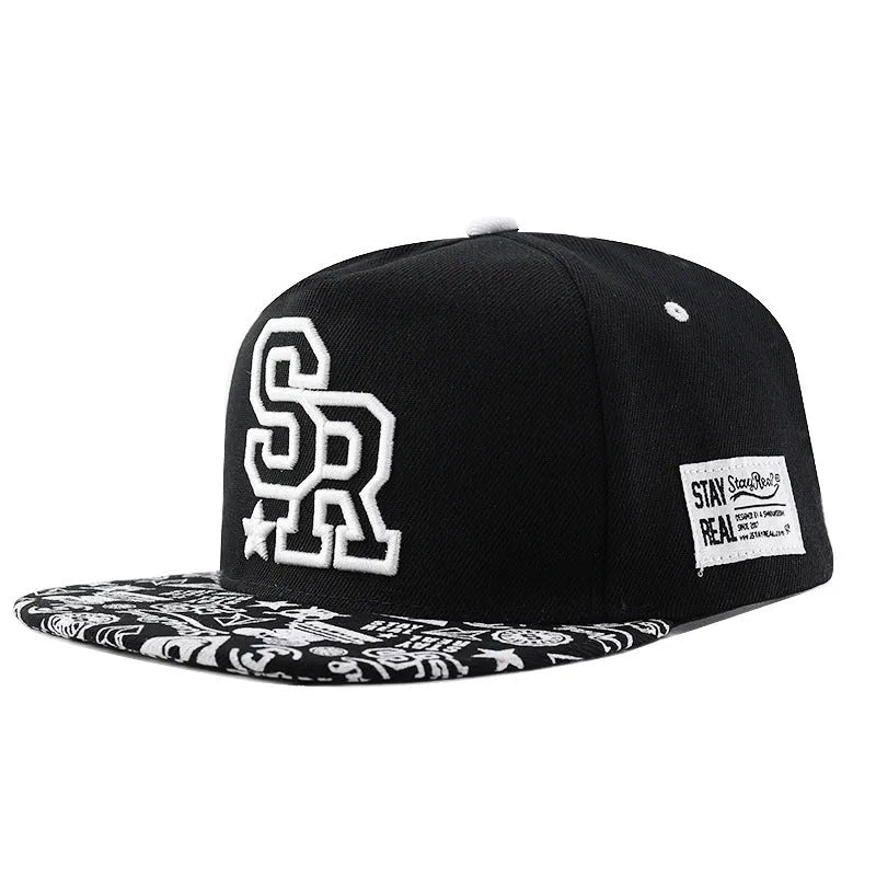 Black and white cotton baseball cap with embroidered letter design on the front.