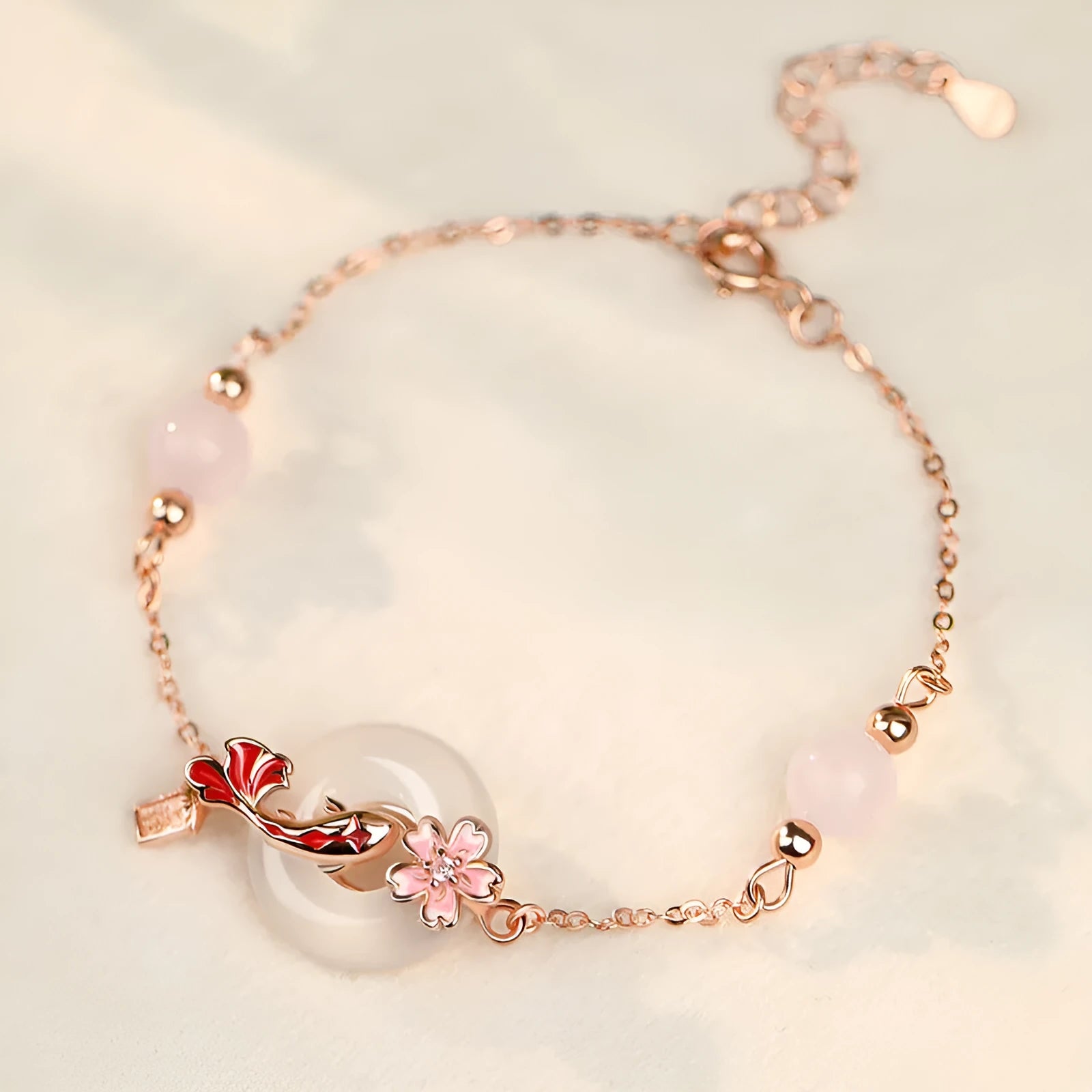 Close-up of a women's S925 sterling silver bracelet with a floral geometric shape, white chalcedony crystal, and a detailed Koi fish motif.