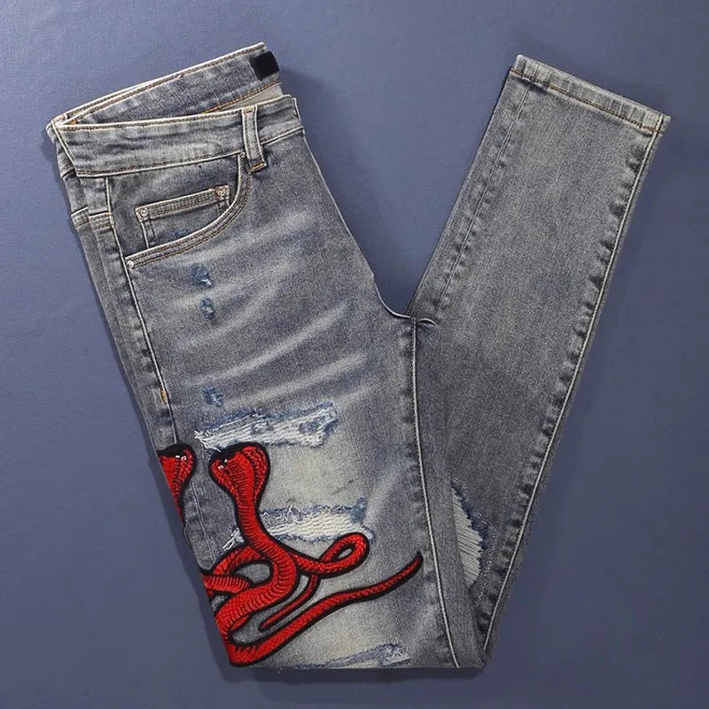 Men's slim fit vintage jeans with a washed-out colour and distressed hole patch embroidery.