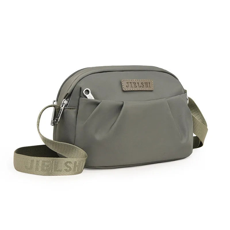 Pleated Oxford cloth crossbody messenger bag in a horizontal square shape with a phone compartment.