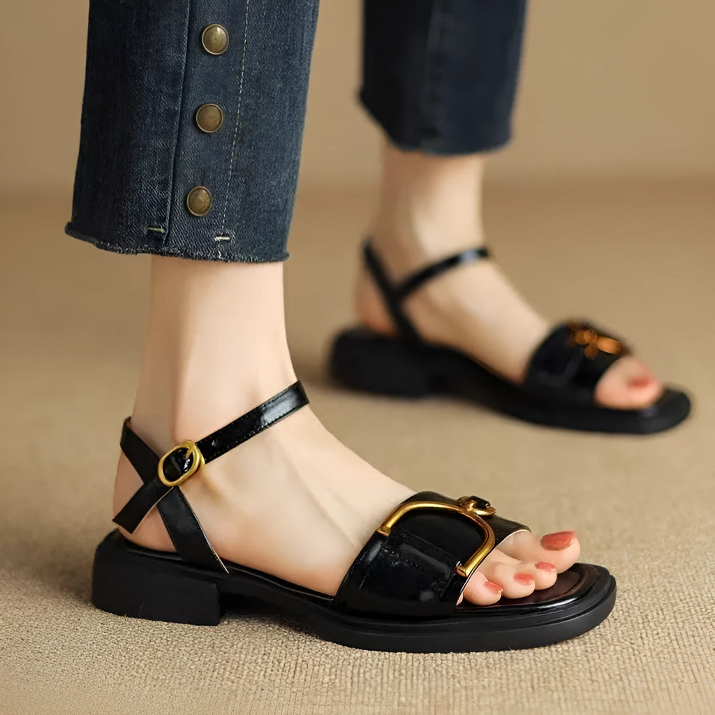 Women's black round-toe sandals with thick rubber sole and button fastening.