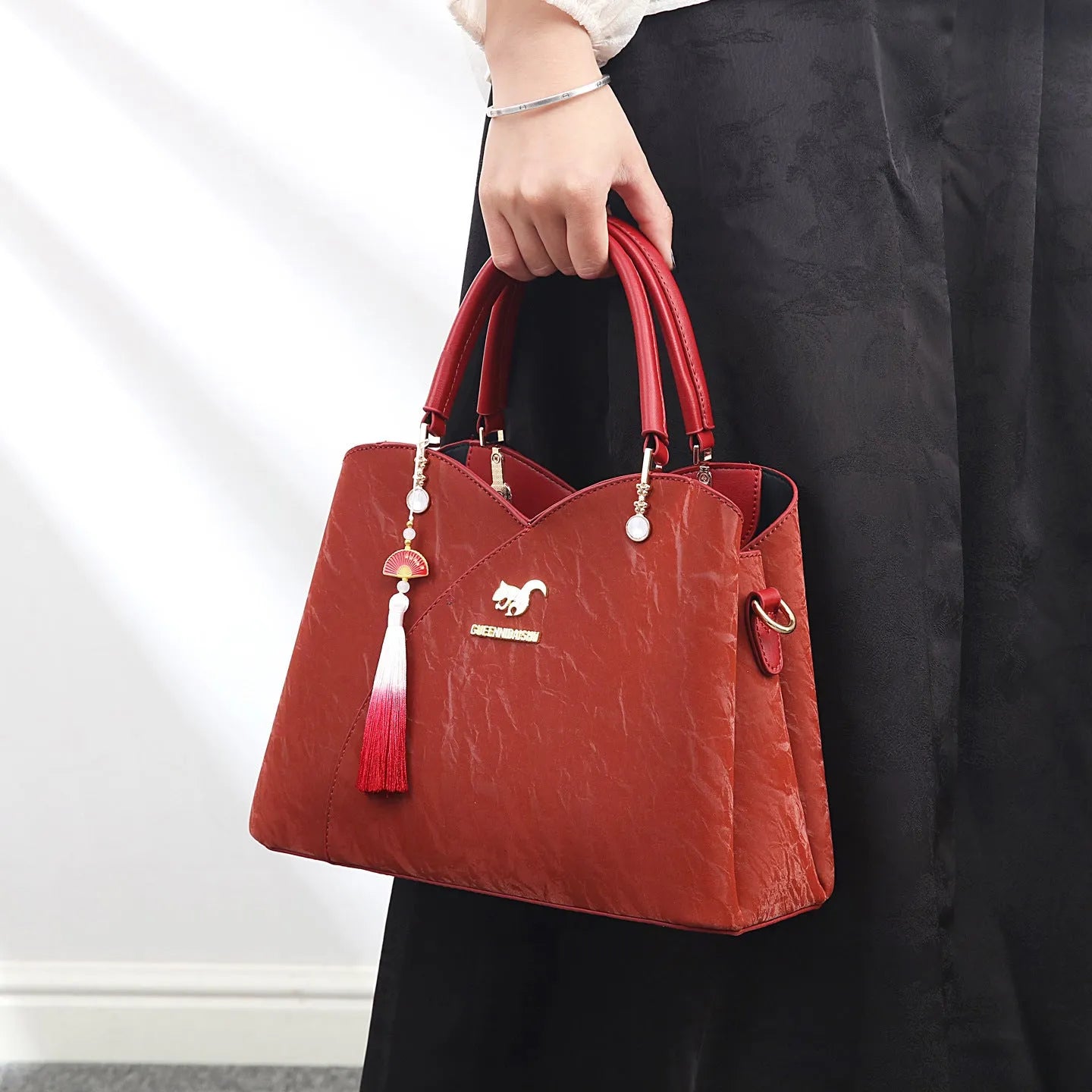 Women's black PU leather messenger bag with sewing thread detail and adjustable shoulder strap