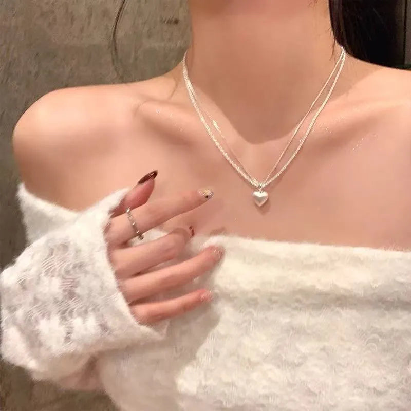 Women's brushed silver double-layer heart pendant necklace on an adjustable chain.