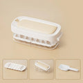 Blue high-capacity ice cube tray with grid design and an ice shovel stored on the side.