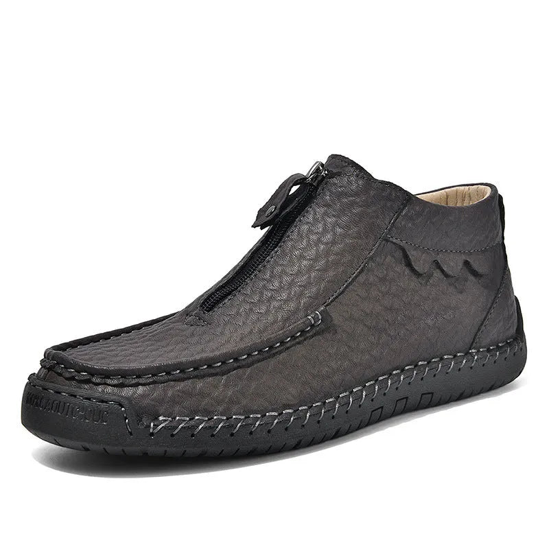 Men's black slip-on loafers with a round toe and sewn rubber sole on a grey background.