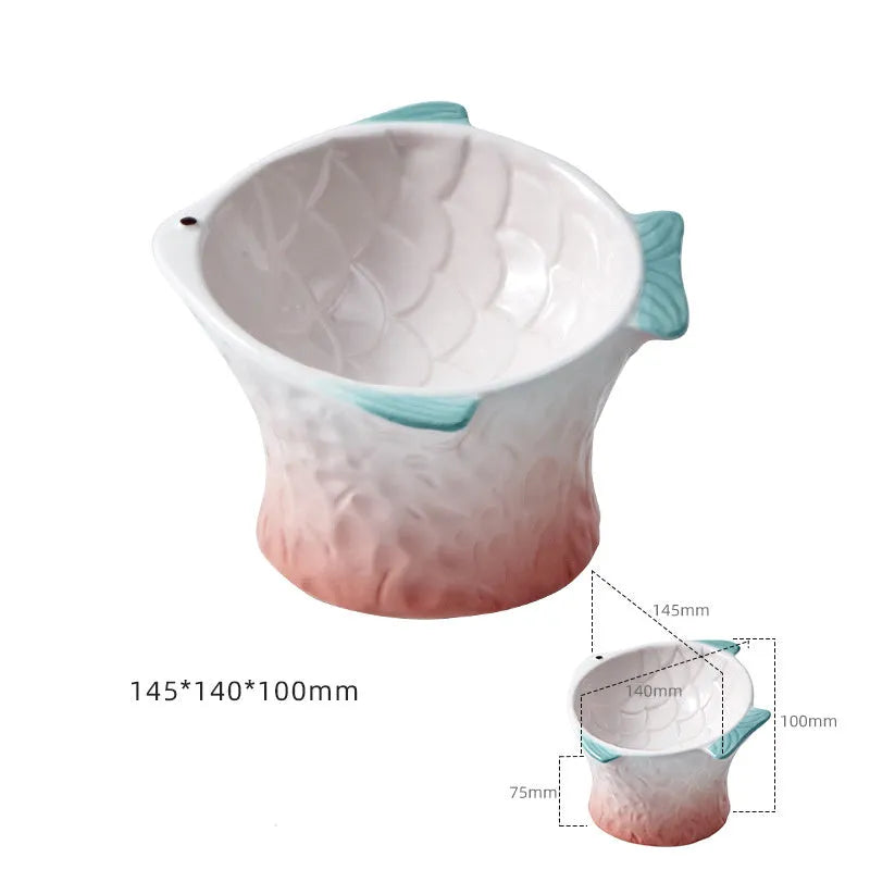 Set of four blue, fish-shaped ceramic cat bowls with a tilted design on a kitchen counter.