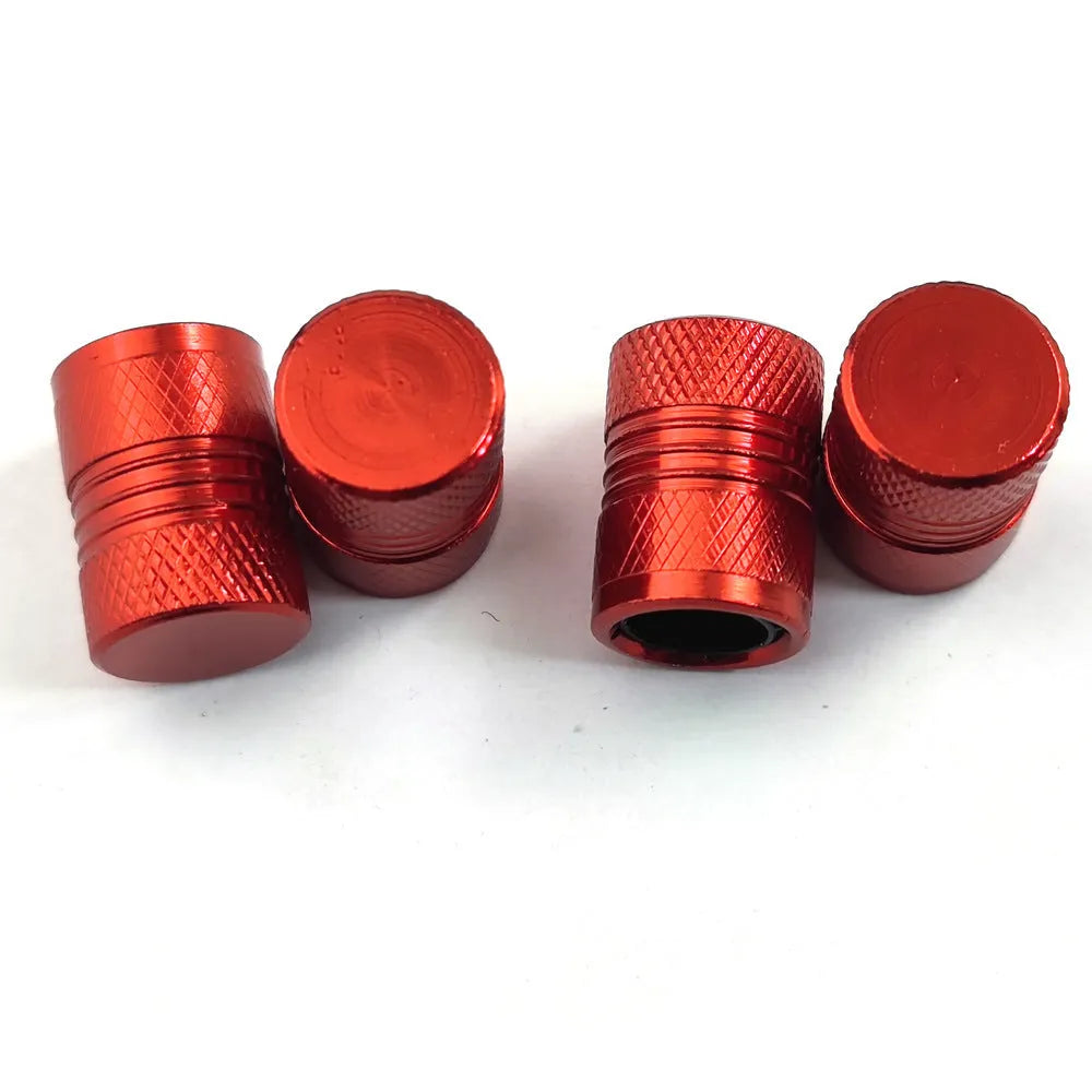 Aluminium car tyre valve dust cap in black, blue, grey, and red colours.