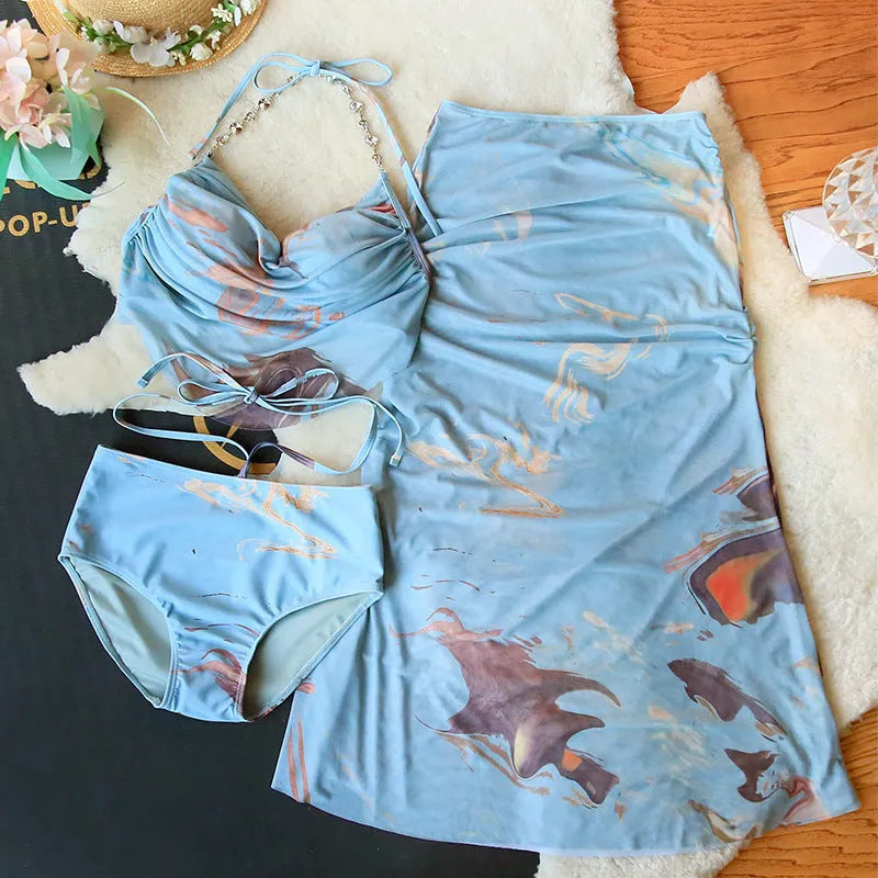 Blue printed women's three-piece bikini set with triangle top, bottoms, and skirt, showing steel support detail.