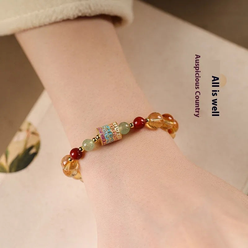 Yellow citrine bracelet with prayer wheel charms and 8mm round beads