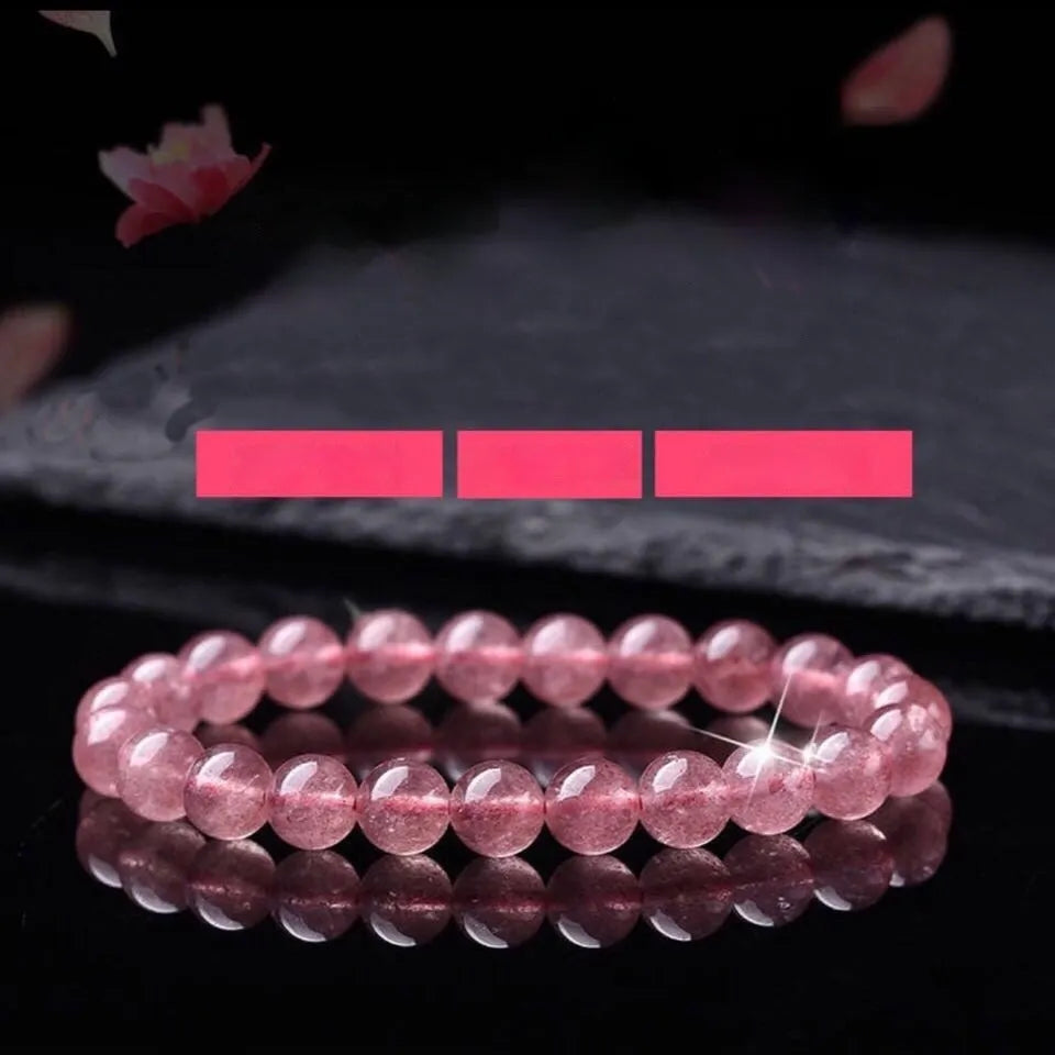 A bracelet made of round, polished pink strawberry quartz beads in three size options.