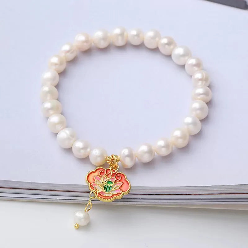 White antique freshwater pearl bracelet with a vintage goldfish and baroque lotus pendant on a chain.
