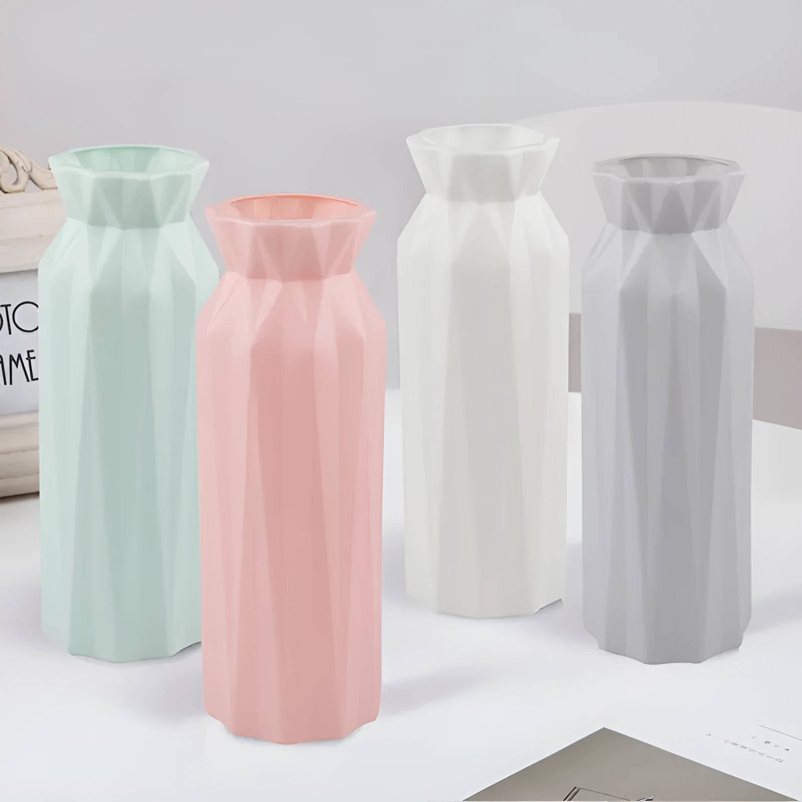 A green drop-resistant plastic melamine vase with a wide 7.2cm base on a wooden table.