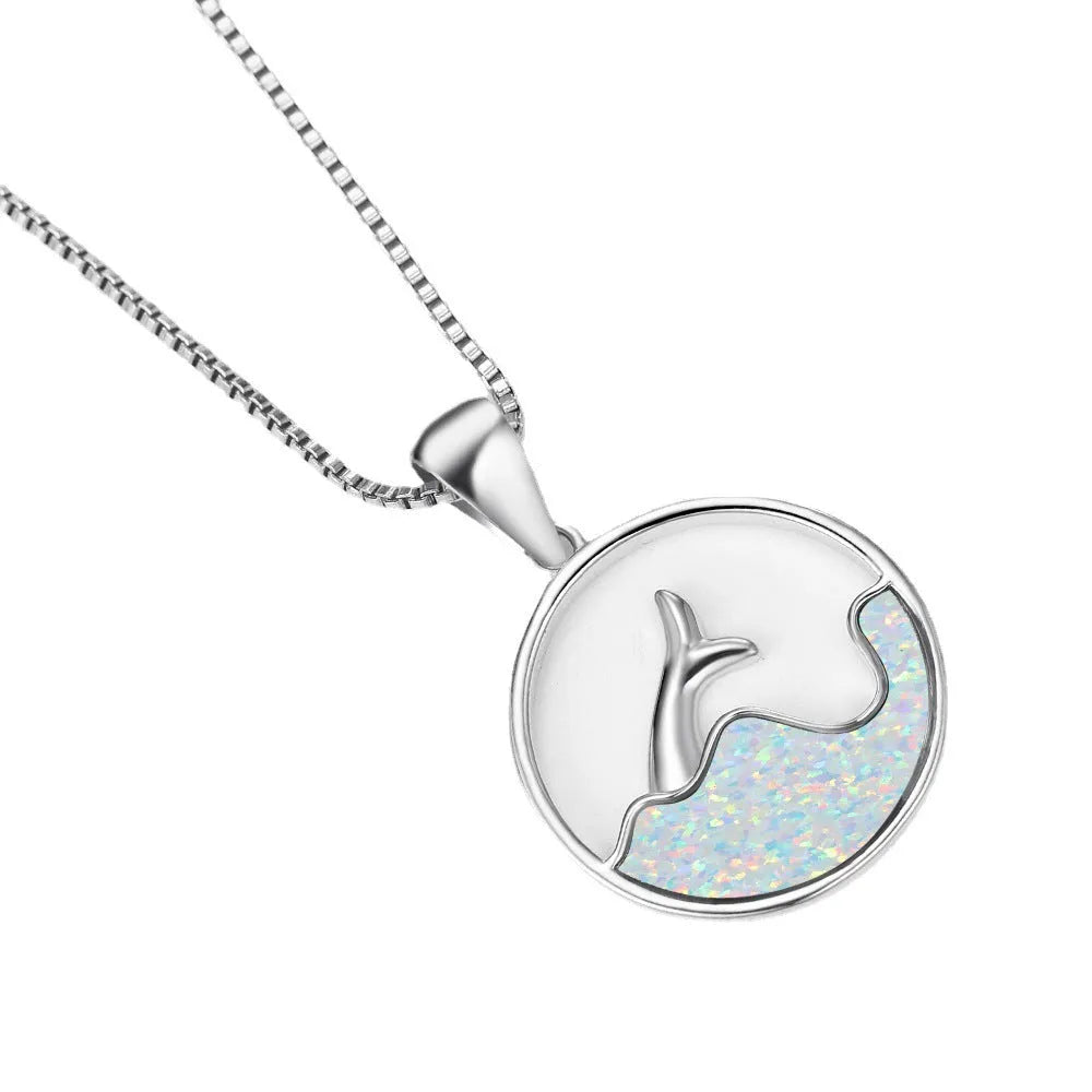 A woman's copper necklace with a round, geometric sea fishtail pendant in a blue opal colour finish.