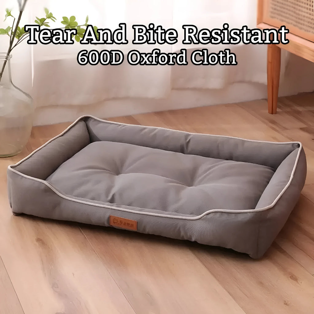 Grey waterproof dog sofa bed with padded sides on a wooden floor