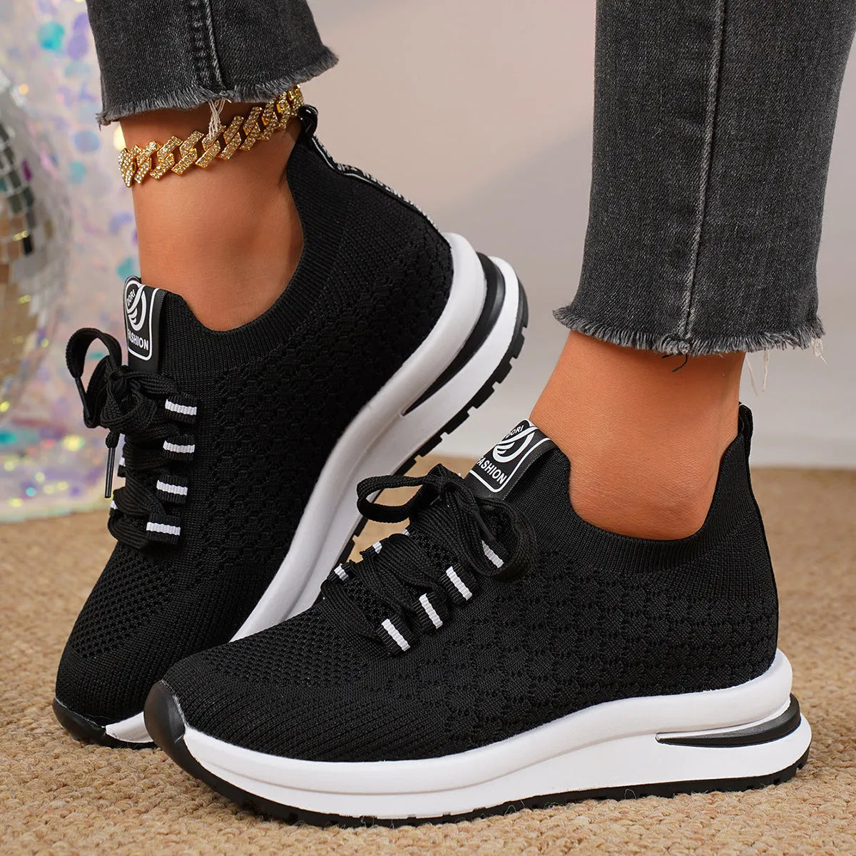 Black and white women's flat lace-up mesh sneakers with round toe on a rubber sole.