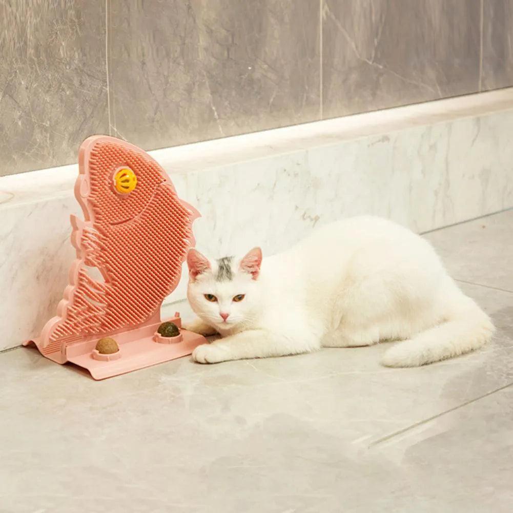 Blue plastic fish-shaped cat wall scratcher with brush, two green catnip balls, a bell, and a base.