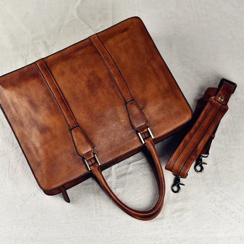 Men's brown leather horizontal business handbag with zippered closure on wooden surface