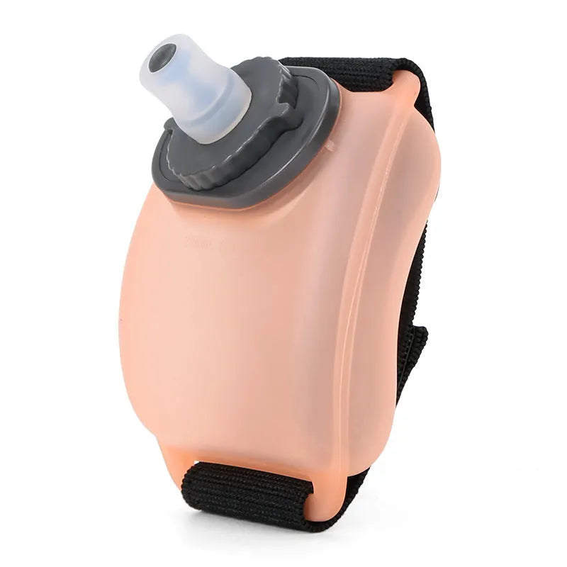 Orange wrist-mounted water bottle with Velcro strap shown on wrist during running activity