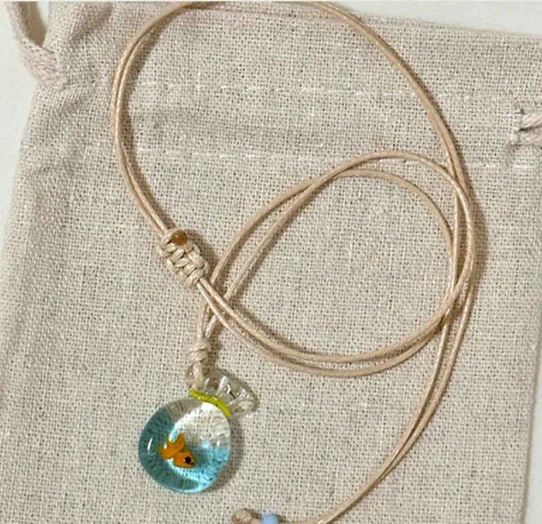 Women's necklace with coloured glaze joker charm on a cotton and linen clavicle chain