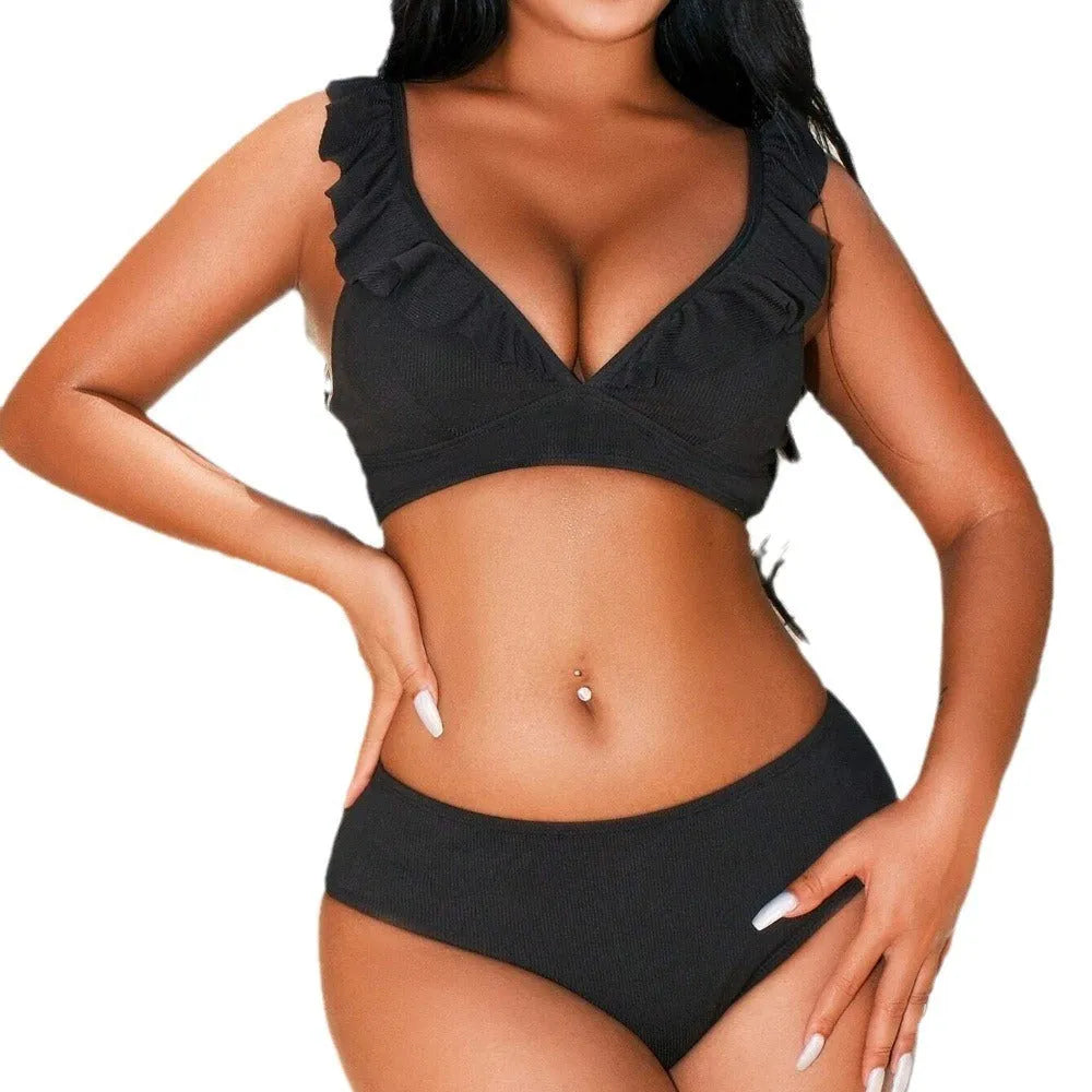 Woman wearing a black and white striped bikini with a V-shaped split-chest design