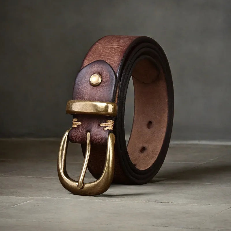 Men's black genuine cattlehide leather belt with a copper pin buckle on a jeans background