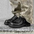 Black leather-style platform shoes with a round toe and low-top design on a white background.