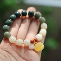 Close-up of a 10mm floral bracelet made from woven Bodhi root with gradient white jade and a natural beeswax lotus bead.