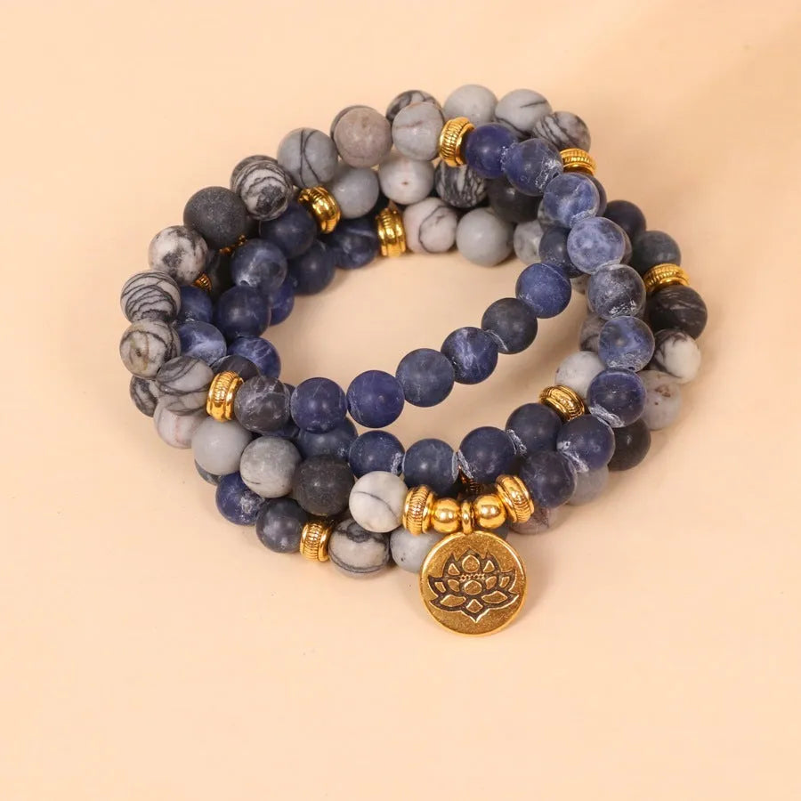 Blue patterned stone bead multi layer alloy bracelet with clasp on a white background.