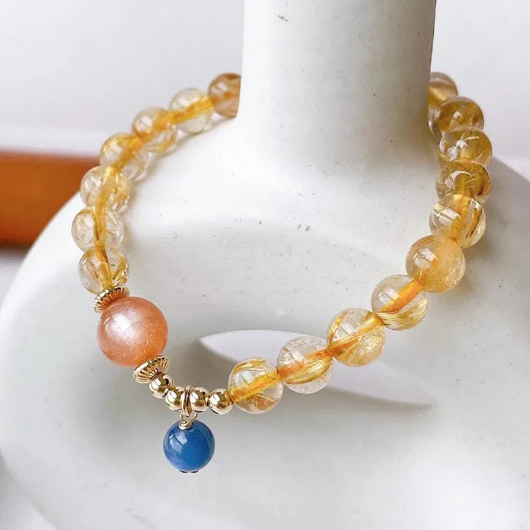 Gold rutilated quartz sunstone crystal bracelet with diamond-shaped beads for women.