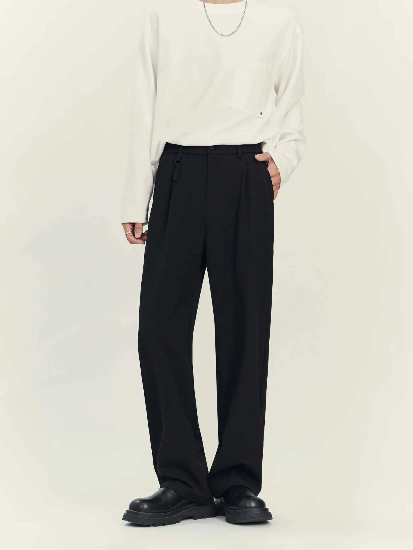 Man wearing black straight-leg business casual trousers with a draping design, made from a polyester blend fabric.