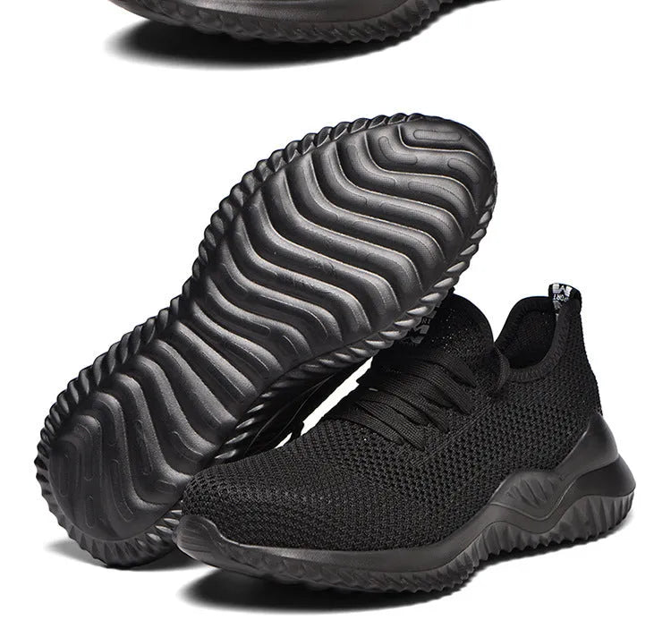 Low-cut black safety shoe with a steel toe cap on a grey background.