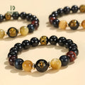 Handmade black agate bracelet with zodiac animal charms and gold tiger eye beads on wrist