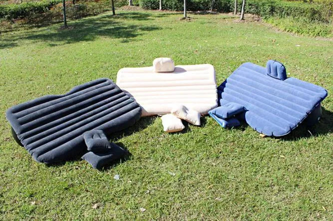 Universal inflatable car air mattress with flocked surface and pillows inside a vehicle.