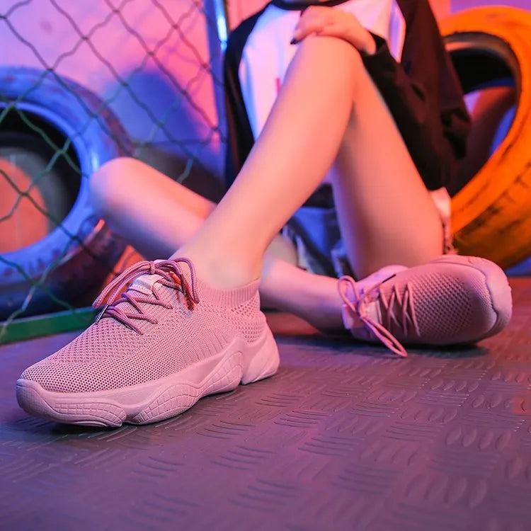 Women's white low-top sports shoes with a woven upper and thick rubber sole.